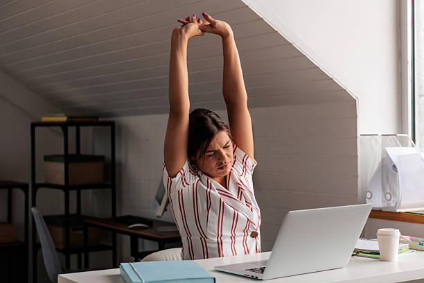 istock Tired Employee Stretching at Desk in Office 2229089423