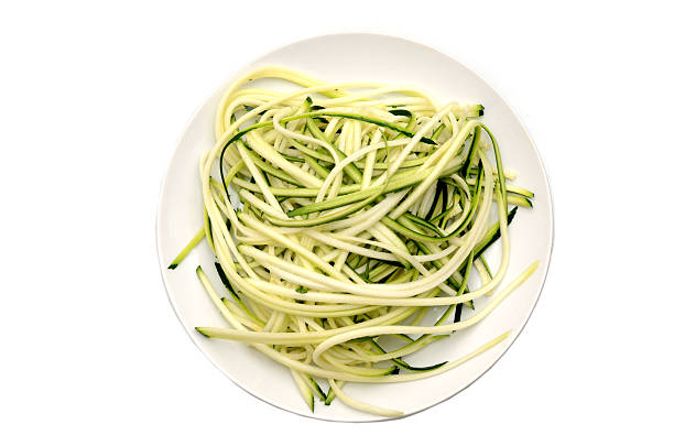 A spaghetti zucchini slices plate on white