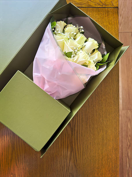 Looking down on a Beautiful roses in a gift box on wooden table