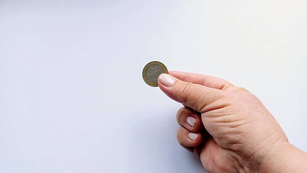 istock A woman holds a coin in her hand. 2229094873