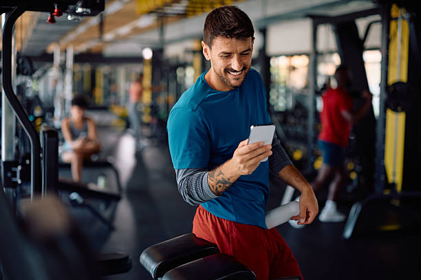 istock Happy athlete using smart phone during sports training in a gym. 2229097400