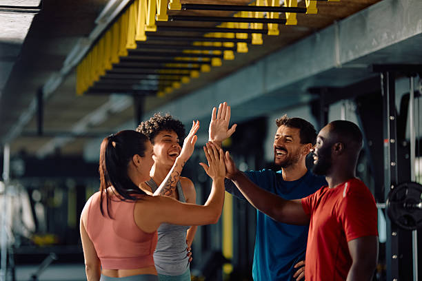 istock Happy athletic friends having fun while gathering hands in unity in a gym. 2229097524