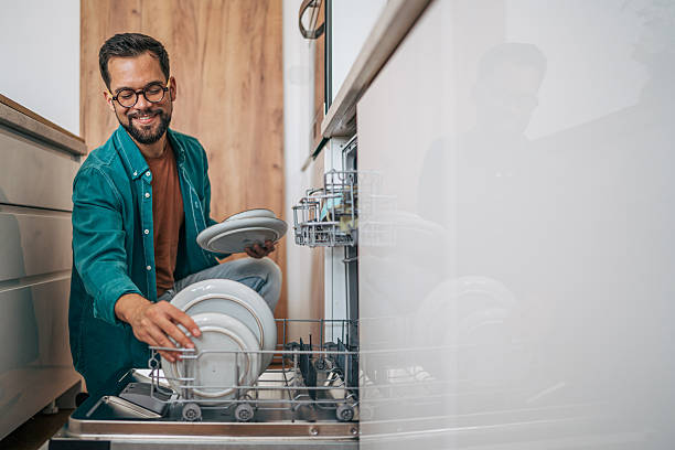 istock Man emptying dishwasher in modern kitchen 2229097687