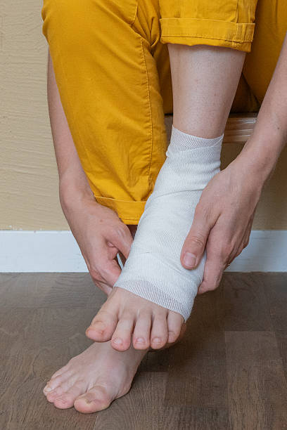 istock Wrapping an ankle injury, first aid and rehabilitation concept 2229098687