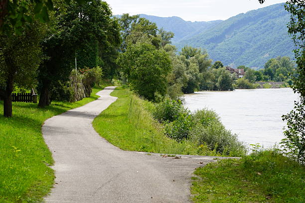 istock Dark storm clouds against the backdrop of mountains and the Danube River. A walking path through the summer countryside. 2229110923