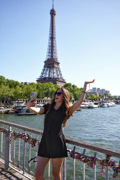 istock Woman taking selfie on bridge with Eiffel Tower in Paris 2229118006