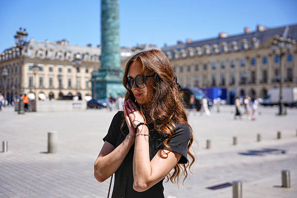 Elegant woman in black t-shirt standing at Place Vendome Paris France on sunny summer day