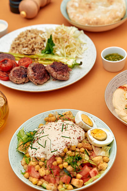 istock Deliciously Prepared Middle Eastern Cuisine Featuring Chickpeas, Fresh Vegetables, Grilled Meats, and Flavorful Accompaniments on a Vibrant Table Setting 2229122356