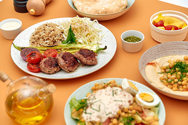 istock Delicious Middle Eastern Feast Featuring Grilled Kebabs, Fresh Salad, Flavorful Hummus, and Rice Accompanied by Olive Oil and Lavish Sides 2229122582