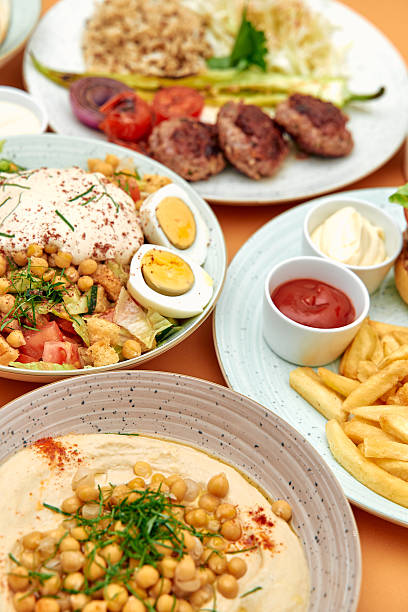istock A Colorful Array of Mediterranean Dishes Featuring Fresh Salads, Delicious Meats, Creamy Dips, and Crispy Fries Amidst Vibrant Ingredients 2229123909