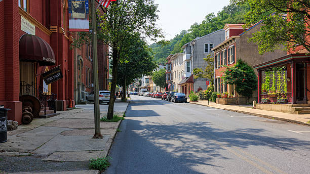 istock Shops lining Broadway street with American flags displayed. Small-town tourism district nestled between mountains in Pennsylvania coal country. 2229125334