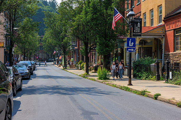 istock Tourists exploring Broadway street with colorful storefronts. Summer shopping district surrounded by mountain landscape in Jim Thorpe, Pennsylvania. 2229125471