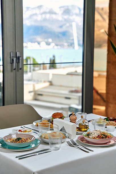 istock A Beautifully Set Table Featuring an Array of Delicious Dishes and Refreshing Views Across the Water with Mountains in the Background 2229125862