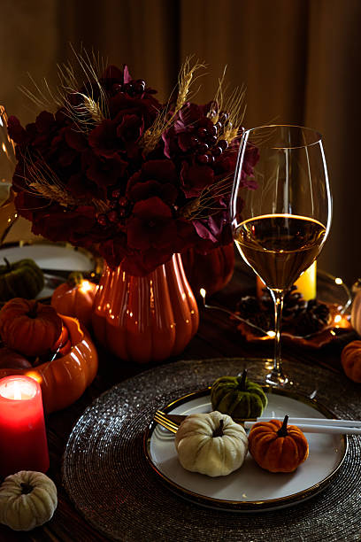 istock Thanksgiving table setting with decorative pumpkins, candles and string lights on dark wooden table 2229127020