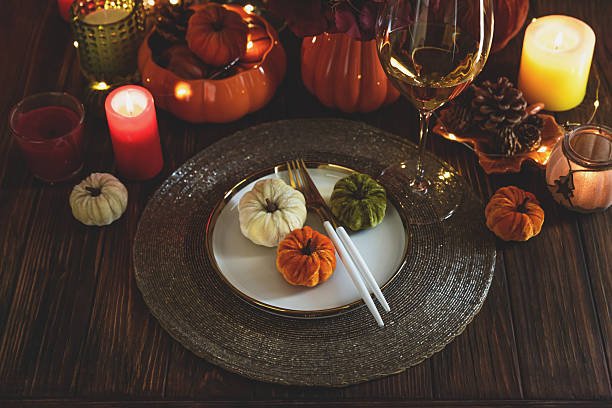 istock Thanksgiving table setting with decorative pumpkins, candles and string lights on dark wooden table 2229127024