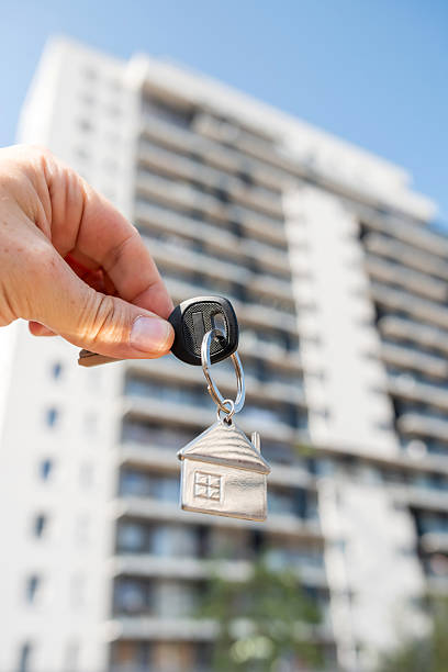 istock A person holds keys in front of a building that is currently under construction 2229128237