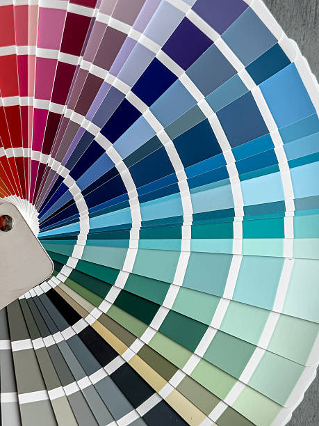 istock catalog of paints with different samples on grey desk.  Rainbow sample colors catalogue. 2229128534