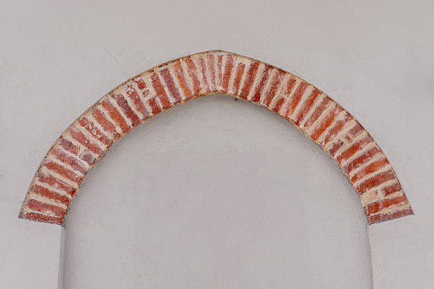 Antique red brick arch on a light gray plastered wall. Texture Graphic element copy space