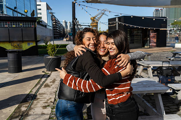 istock Three young women hugging each other outdoors in urban setting 2229129552