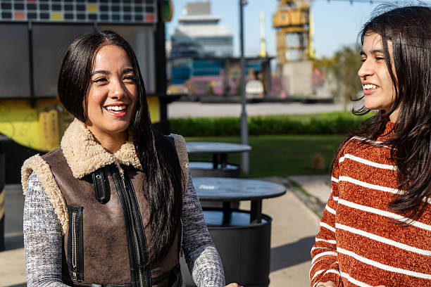 istock Two young women laughing together outdoors in urban setting 2229129683