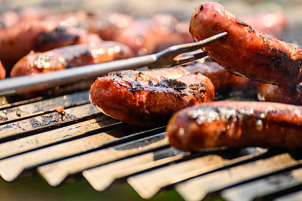 The process of grilling sausages for a party. A Party Food Preparation