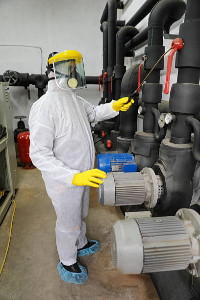 istock Older Man Sprays Boiler Room with Protective Gear for Sanitization 2229133156