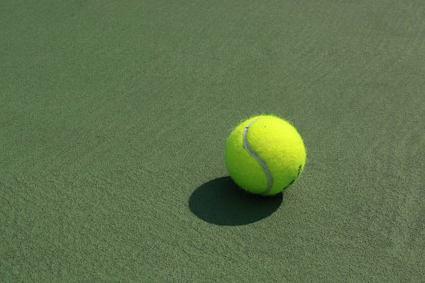 Yellow tennis ball on a green court