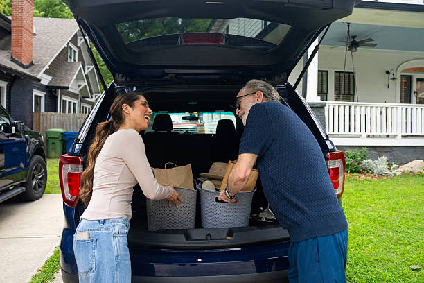istock Senior man receiving assistance from his adult daughter while loading boxes into car trunk. 2229135845
