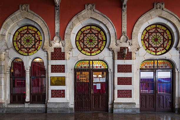 Istanbul, Turkey - November 10, 2023: Ornate facade of the historic Sirkeci Terminal with contrast brick walls and star pattern stained glass windows