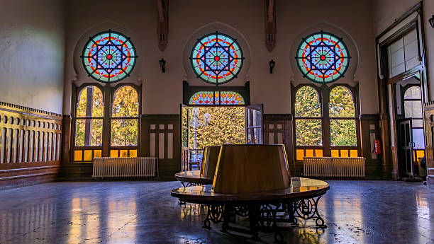 Istanbul, Turkey - November 10 2023: Grand interior of historic Sirkeci Terminal with ornate wooden benches and star patterned stained glass windows