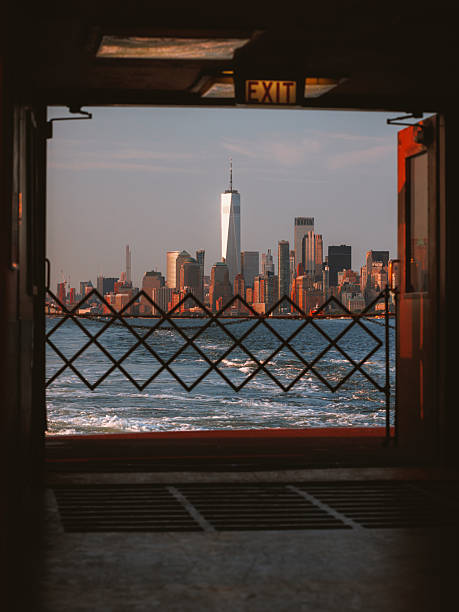 Manhattan with Battery Park, wood jetty and Hudson river in the forefront, during winter evening with overcast, horizontal