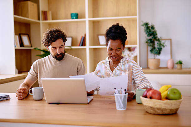 istock Coworkers reviewing documents and working on a laptop in the office 2229142477