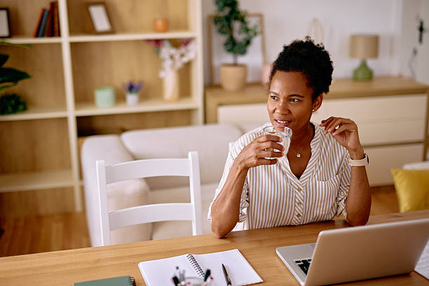 istock Black freelancer woman drinking water while working from home 2229142482