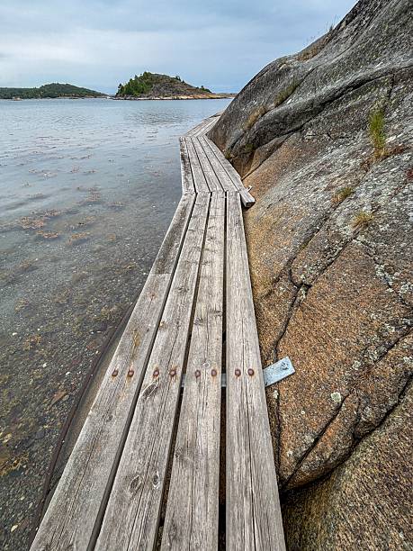 istock Scenic wooden boardwalk by rocky shore. 2229143206