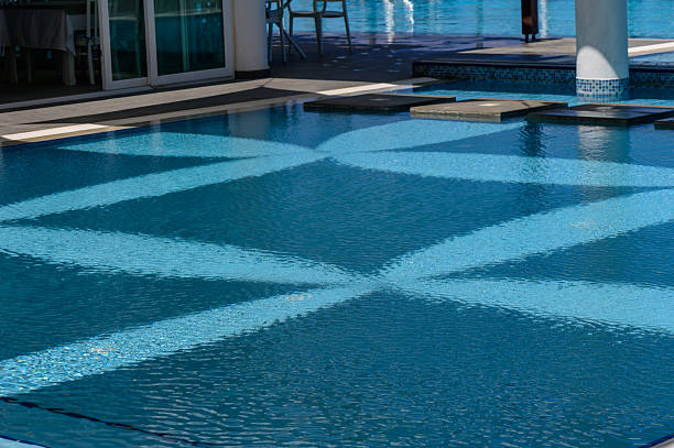A stunning view of a luxury infinity pool beside a pristine sandy beach, with turquoise ocean waters in the background. The modern design, relaxing lounge chairs, and crystal-clear pool create a serene vacation atmosphere, perfect for themes of travel, leisure, summer holidays, and resort living.