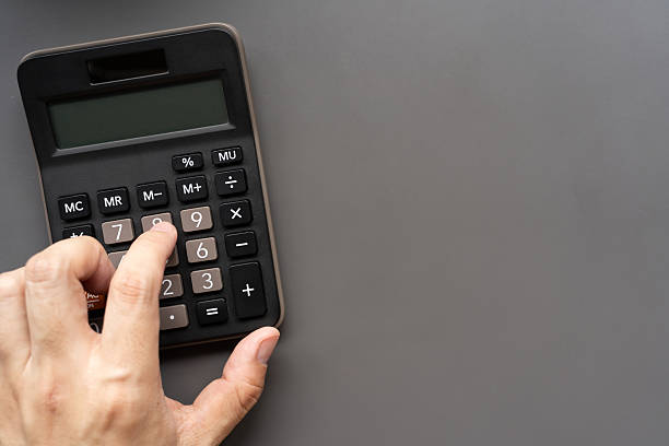 Right Hand Using Calculator with Copy Space. Financial Planning Concept. Budget Planning. Financial management, business organization, management, or tax preparation themes.