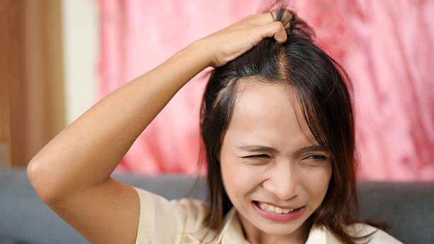 istock Frustrated woman pulling hair, expressing stress and anxiety in domestic setting. background features soft pink tones, enhancing emotional intensity of moment 2229174213