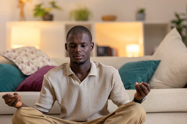 istock Serene young man practicing meditation in his living room, finding inner peace and mindfulness 2229175098