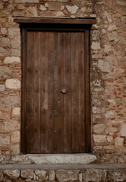 istock Old wooden door in stone wall. 2229175950
