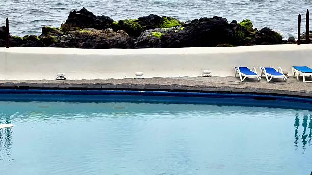 istock Relax at the Serene Oceanfront Pool with Comfortable Lounge Chairs for Ultimate Enjoyment 2229176502