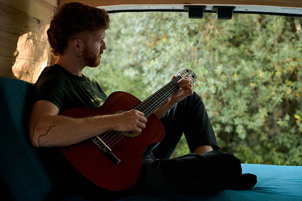istock Musician playing acoustic guitar in camper van 2229178193