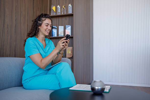 istock Smiling doctor using smartphone and relaxing on sofa in modern clinic 2229178265