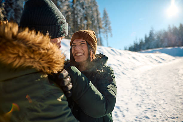 Happy couple hugging and laughing in winter landscape