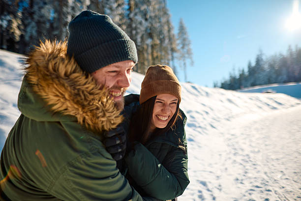 istock Young couple laughing and having fun in the snow 2229187929