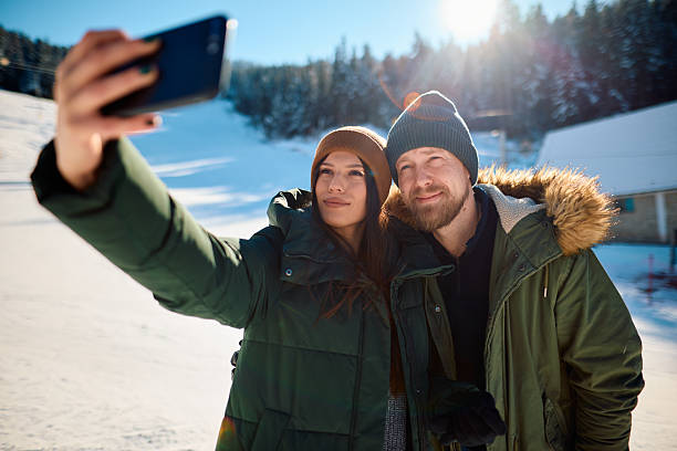 istock Young couple taking selfie in snowy mountain landscape 2229188090