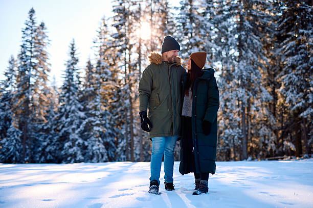 istock Young couple enjoying a romantic walk in snowy winter forest 2229188105