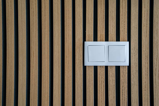 istock Wooden wall texture with wood acoustic panels and light switch 2229189000