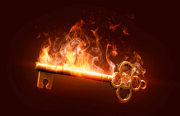 A glowing golden key is engulfed in fiery red-orange flames, representing power and determination, and matches the theme of the key of opportunity within the image. The flames surrounding the key may symbolize challenge or motivation, while the key itself stands out, representing its potential to unlock the opportunities that lie ahead. The background is a darker background that accentuates both the flames and the key.