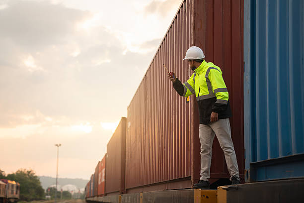 istock Foreman checking inventory or task details on freight train cars and shipping containers. Logistics concept, import, and export industries. 2229191506