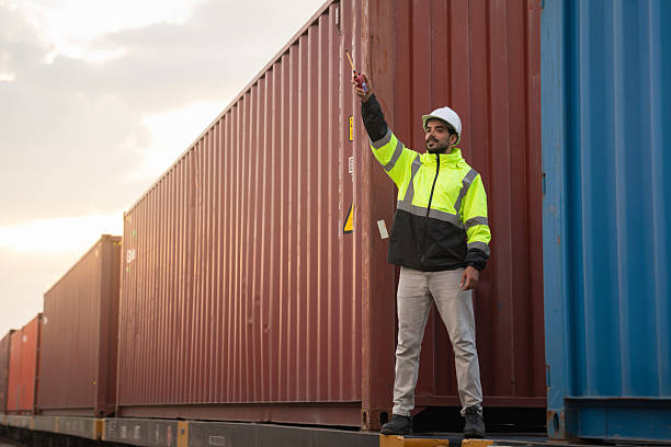 istock Foreman checking inventory or task details on freight train cars and shipping containers. Logistics concept, import, and export industries. 2229191637